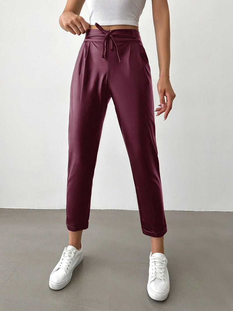 Pantalones largos de tela metalica con nudo frontal para mujer