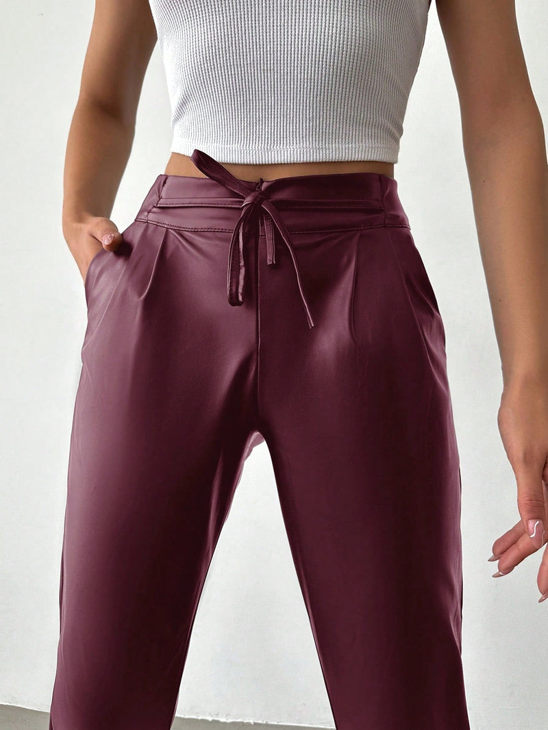 Pantalones largos de tela metalica con nudo frontal para mujer